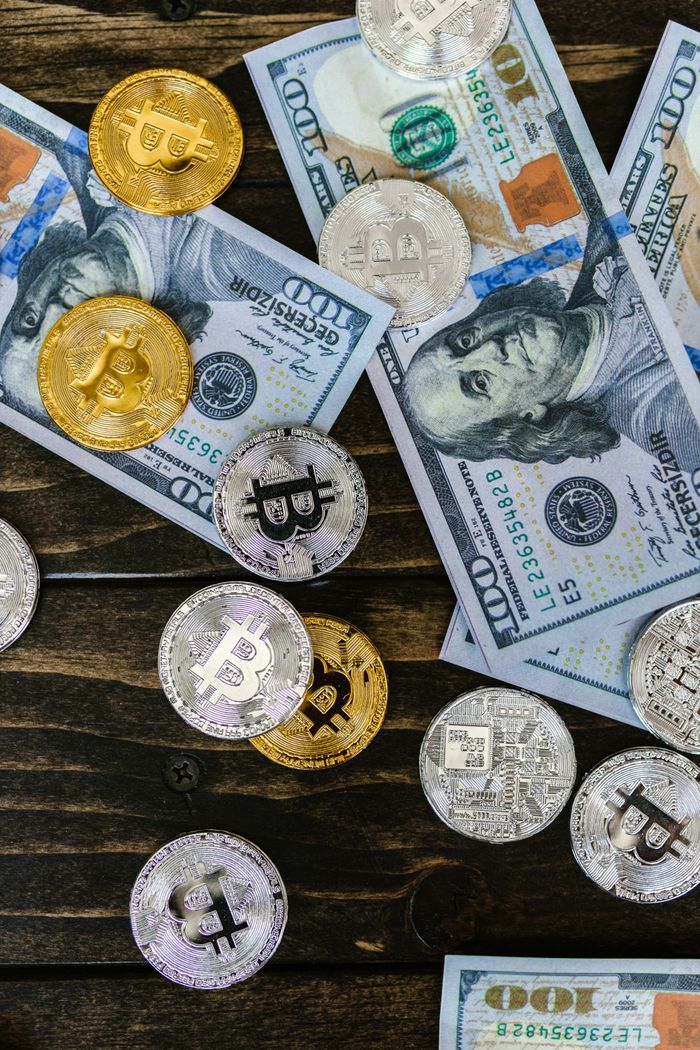 Colorful mix of bitcoins and US dollar bills, showcasing cryptocurrency and finance investment.